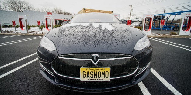 A Model S electric vehicle (EV) with a personalized license plate charges at a supercharger station at the Tesla Motors Inc.