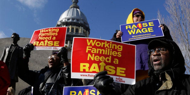 In this Thursday, Nov. 20, 2014 photo, supporters of legislation that will raise the minimum wage in Illinois rally outside the Illinois State Capitol in Springfield Ill. Much is at stake as Republican Gov.-elect Bruce Rauner, who has asked lawmakers not to move major legislation until after he takes office, picks his own loyalists and others to replace Gov. Pat Quinn's people across state government. Illinois has not had a transition from one party to another since Rod Blagojevich took over for George Ryan in 2003. (AP Photo/Seth Perlman)