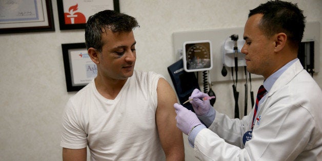 FORT LAUDERDALE, FL - JANUARY 06: Gautam Gupta receives an influenza shot from Nurse Practitioner Ray Grigorio in the MinuteClinic at the CVS/pharmacy on January 6, 2014 in Fort Lauderdale, Florida. The 2013-2014 influenza season is starting to take off in the United States, with more than half the country reporting widespread cases of flu activity, according to the US Centers for Disease Control and Prevention. (Photo by Joe Raedle/Getty Images)