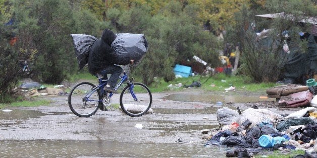 With AFP Story by Veronique DUPONT: US-Poverty-Homeless-TechnologyA man rides along a muddy path carrying his belongings at the Silicon Valley homeless encampment known as 'The Jungle' on Wednesday, December 3, 2014 in San Jose, California. More than 300 residents of the shantytown have been given notices to leave the area by the morning of Thursday, December 4, 2014. Many of have nowhere else to go. AFP PHOTO/JOSH EDELSON (Photo credit should read Josh Edelson/AFP/Getty Images)