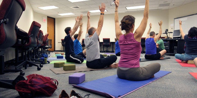 CAMBRIDGE, MA - JUNE 3: Noon office yoga class at Draper Laboratory, one of Draper's employee wellness initiatives. Draper is a Cambridge research lab that also promotes diversity by offering transgender health services and other benefits through its insurance, Harvard Pilgrim Health Care. Draper executives say honoring employee diversity and wellness is part of their mission. (Photo by Joanne Rathe/The Boston Globe via Getty Images)