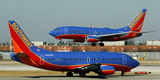 FILE - In this Feb. 9, 2012, file photo, a Southwest Airlines Boeing 737 waits to take off at Chicago's Midway Airport as another lands. The government can require airlines to show consumers a total ticket price that includes taxes and fees in print and online ads, the U.S. Court of Appeals said Tuesday, July 24, 2012, rejecting an industry challenge to a series of consumer protection regulations. The Department of Transportation, which issued the regulations last year, has the authority to regulate âunfair and deceptiveâ airline industry practices, the three-member panel said in its ruling. The ruling also covers two other regulations: A requirement that airlines allow consumers who purchase tickets more than a week in advance the option of canceling their reservations without penalty within 24 hours after purchase, and a ban on airlines increasing the price of tickets or baggage fees after tickets have been bought. The rules had been challenged by Spirit and Southwest airlines, with the support of two major airline industry trade associations. (AP Photo/Charles Rex Arbogast, File)