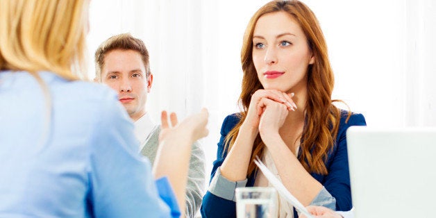 Commission having a job interview with young woman candidate. Selective focus to young businessman just looking at candidate.