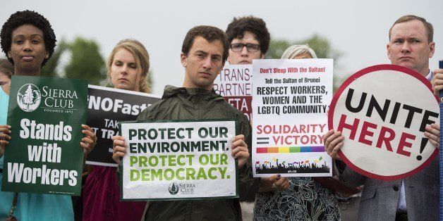 Activists stand with placards opposing the Trans-Pacific Partnership (TPP) during a news conference on Capitol Hill in Washington, DC, July 9, 2014. AFP PHOTO / Jim WATSON (Photo credit should read JIM WATSON/AFP/Getty Images)