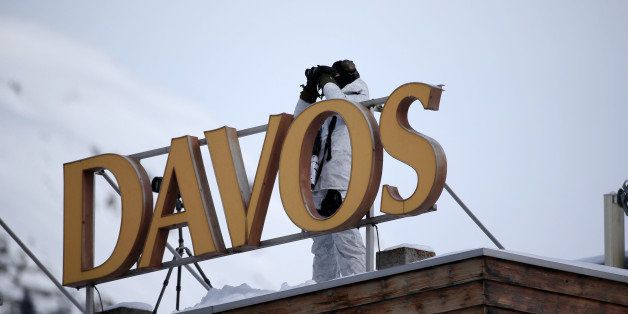 A member of the Swiss police force uses binoculars to look out from the roof of the Hotel Davos during surveillance operations ahead of the World Economic Forum (WEF) in Davos, Switzerland, on Tuesday, Jan. 20, 2015. This week World leaders, influential executives, bankers and policy makers will attend the 45th annual meeting of the World Economic Forum in Davos that runs from Jan. 21-24. Photographer: Simon Dawson/Bloomberg via Getty Images