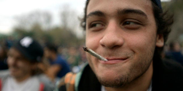 A young man smokes a marijuana cigarette at a park where people gathered to mark the First Worldwide March for Regulated Marijuana in Montevideo, Uruguay, Saturday, May 3, 2014. Uruguay released its rules Friday afternoon for the legal marijuana market it is launching this year. In Uruguay, consumers must be licensed, and each purchase will be tracked to ensure they buy no more than 10 grams a week, said Mujica who along with his minister will sign the regulations on Monday, and they'll take effect on Tuesday. (AP Photo/Matilde Campodonico)