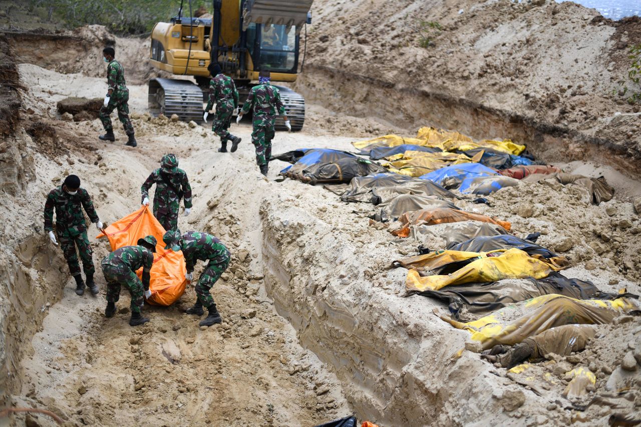 Indonesian soldiers buried quake victims in a mass grave in Poboya on Tuesday.