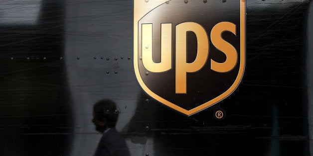 SAN FRANCISCO, CA - JUNE 17: A pedestrian walks by a United Parcel Service (UPS) truck on June 17, 2014 in San Francisco, California. UPS announced plans to begin to consider box size in the pricing of ground shipments in the U.S. and standard delivery to Canada. (Photo by Justin Sullivan/Getty Images)