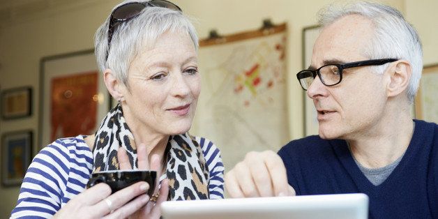 mature man and woman in cafe with digital tablet