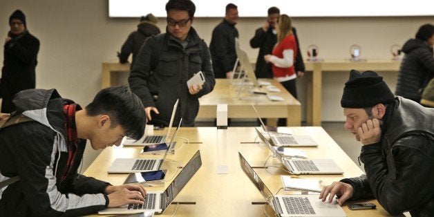 Customers looks over the products at an Apple store in New York, Thursday, Jan. 8, 2015. (AP Photo/Seth Wenig)