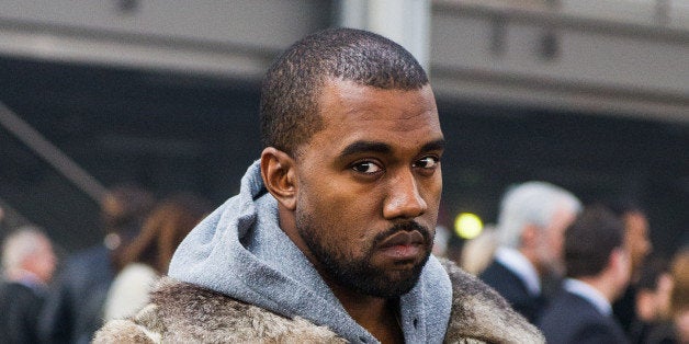 Rap singer Kanye West poses for photographers as he arrives to attend the Givenchy men's Fall-Winter 2014-2015 fashion collection, presented Friday, Jan. 17, 2014 in Paris. (AP Photo/Zacharie Scheurer)