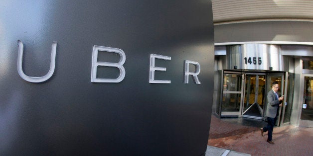 In this photo taken Tuesday, Dec. 16, 2014, a man leaves the headquarters of Uber in San Francisco. (AP Photo/Eric Risberg)