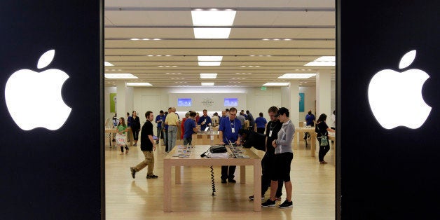 FILE - In this Friday, Oct, 26, 2012, file photo, people shop at an Apple store inside a mall in Cheektowaga, N.Y. Apple Inc. paid a rate of only 1.9 percent income tax on its earnings outside the U.S. in its latest fiscal year, a regulatory filing by the company shows. The world's most valuable company paid $713 million in tax on foreign earnings of $36.8 billion in the fiscal year ended Sept. 29, according to the financial statement filed on Oct. 31. (AP Photo/David Duprey, File)