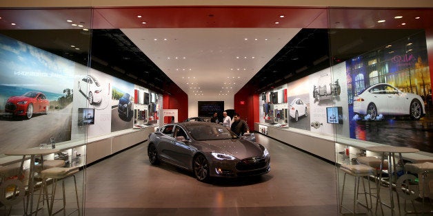 MIAMI, FL - FEBRUARY 19: People look at a Tesla Motors vehicle on the showroom floor at the Dadeland Mall on February 19, 2014 in Miami, Florida. Tesla said today it earned $46 million in the fourth quarter on a non-adjusted basis, or 33 cents a share, causing shares in the company to jump 12 percent. (Photo by Joe Raedle/Getty Images)