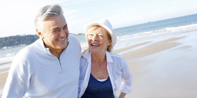 Senior couple walking on the beach in fall season