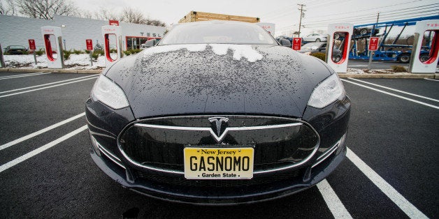 A Model S electric vehicle (EV) with a personalized license plate charges at a supercharger station at the Tesla Motors Inc.