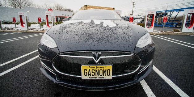 A Model S electric vehicle (EV) with a personalized license plate charges at a supercharger station at the Tesla Motors Inc. Gallery and Service Center in Paramus, New Jersey, U.S., on Thursday, Dec. 11, 2014. Tesla rose 1.2 percent at the end of trading mid last week to close at $216.89 after falling as low as $204.27. For the year, the shares have gained 44 percent. Photographer: Ron Antonelli/Bloomberg via Getty Images