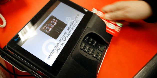 FILE - In this Friday, Nov. 28, 2014 file photo, a shopper pays for her purchases at a Target store in South Portland, Maine. Criminals stole personal information from tens of millions of Americans in data breaches last year. Of those affected, one in three became victims of identity theft, according to research firm Javelin. (AP Photo/Robert F. Bukaty, File)