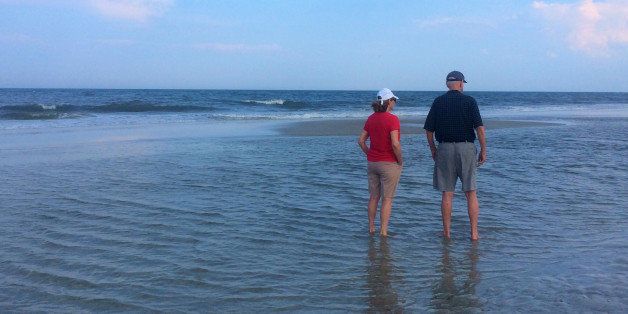 Senior couple wading at the beach , Jacksonville Beach, Florida , USA on August 17 , 2014. 