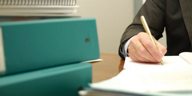 Busy businessman writing paperwork