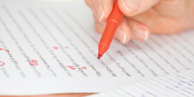 Proofreader with red pen checks a transcribed page