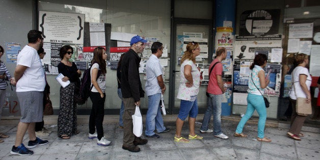 Jobseekers queue to enter an OAED employment center shortly after opening in Athens, Greece, on Wednesday, Sept. 10, 2014. Over the past two years, real wages fell in Greece, Portugal, Ireland, Spain and Italy, the OECD said Sept. 3 in a report on employment. Photographer: Kostas Tsironis/Bloomberg via Getty Images