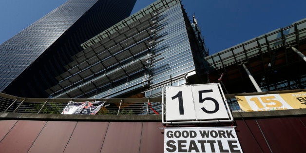 A sign that reads "15 Good Work Seattle" is displayed below Seattle City Hall, right, and the Columbia Center building, left,