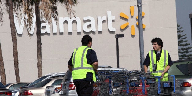 LOS ANGELES, CA - FEBRUARY 19: Workers retrieve shopping carts at the Crenshaw Plaza parking lot near the Wal-Mart on Februar