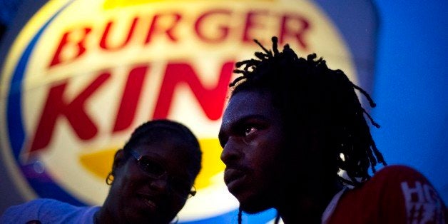 Joshua Collins, right, and Marie Mdamu, talk outside a Burger King restaurant during a protest by fast-food workers calling for the federal minimum wage to be raised to $15, Wednesday, April 15, 2015, in College Park, Ga. Organizers say they chose April 15, tax day, to demonstrate because they want the public to know that many low-wage workers must rely on public assistance to make ends meet. (AP Photo/David Goldman)