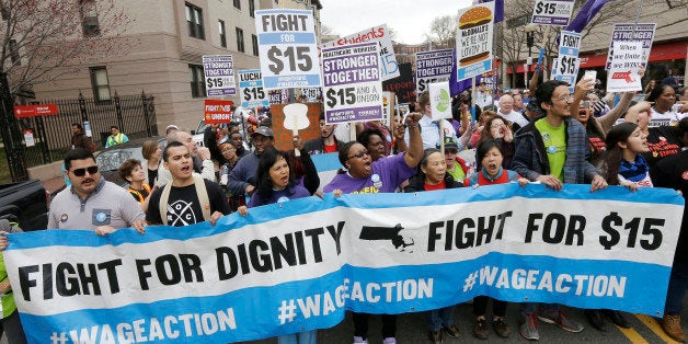 Protesters, including college students, fast-food restaurant employees and other workers, display placards and chant slogans as they march, Tuesday, April 14, 2015, in Boston. Organizers of the event are calling for the nation's lowest paid workers to earn at least $15 per hour. (AP Photo/Steven Senne)