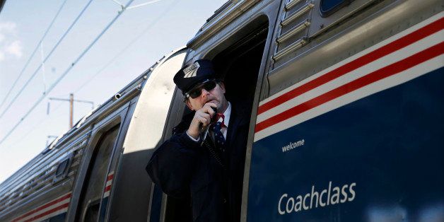 Amtrak conductor Michael Laubauskas talks on a radio as his train departs for Washington, D.C., as the state Chamber of Commerce commences its annual "Walk to Washington," Thursday, Feb. 19, 2015, in Trenton, N.J. Billed as the state's "premiere networking event," Thursday's "walk" gets its name because many of the nearly 600 attendees spend most of their time walking along train cars, shaking hands and meeting peers. The chamber chartered 14 cars and members pay nearly $600 to attend while non-members dole out nearly $700 for the event. (AP Photo/Mel Evans)
