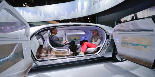 Attendees sit in the self-driving Mercedes-Benz F 015 concept car at the Mercedes-Benz booth at the International CES Tuesday