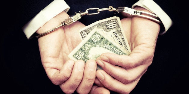 Businessman Hands in Handcuffs Holding Ten Dollar Bill