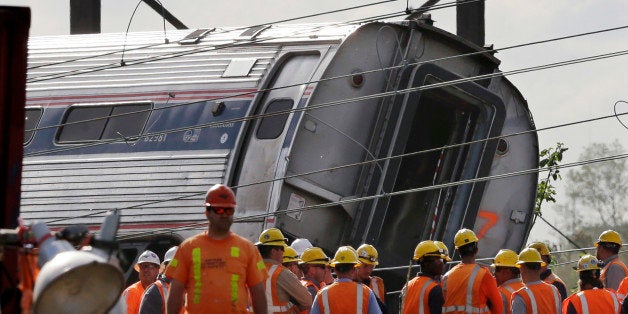 Emergency personnel gather near the scene of a deadly train derailment, Wednesday, May 13, 2015, in Philadelphia. The Amtrak train, headed to New York City, derailed and crashed in Philadelphia on Tuesday night, killing at least six people and injuring dozens of others. (AP Photo/Mel Evans)