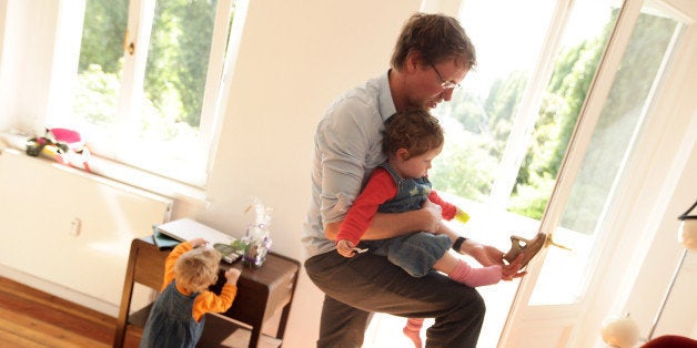 BERLIN - AUGUST 31: Oliver H., 42, a married federal employee on 6-month paternity leave, puts shoes on his twin 14-month-old daughter Lotte while her sister Alma plays nearby at his home on August 31, 2010 in Berlin, Germany. Under German law married couples may take 14 months parent leave, to be divided between the two spouses, during which an individual receives two thirds of his or her normal income from the state, up to EUR 1,800 a month. In order to encourage more fathers to take paternity leave, German Family Minister Kristina Schroeder is seeking to lengthen parent leave from the current 14 months to 16 months, though German Finance Minister Wolfgang Schaeuble sees the measure as too expensive. (Photo by Sean Gallup/Getty Images)