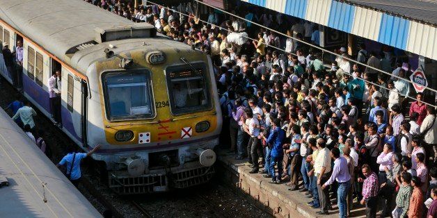 Commuters wait to catch a train at a railway station in Mumbai, India, Thursday, Feb. 26, 2015. Indian Railway minister Suresh Prabhu will unveil the Rail Budget 2015 on Thursday for one of the worldâs largest railways systems that serves more than 23 million passengers a day. (AP Photo/Rafiq Maqbool)