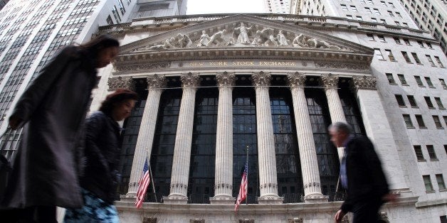 People walk past the New York Stock Exchange (NYSE) building on March 11, 2015 in New York. The average Wall Street bonus ros