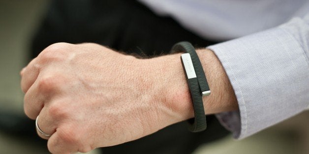 A man wears an UP fitness wristband in Washington on July 16, 2013. Jawbone, the San Francisco-based company behind 'smart' wireless earpieces and Jambox speakers, late last year released redesigned UP wristbands that combine fashion with smartphone lifestyles to help people along paths to improved fitness. UP wristbands are priced at $129 in the United States. UP applications tailored for Apple or Android mobile devices collect data from the bands to let people get pictures of activity, sleep, eating, and even moods on any given day or over time. AFP PHOTO/Nicholas KAMM (Photo credit should read NICHOLAS KAMM/AFP/Getty Images)