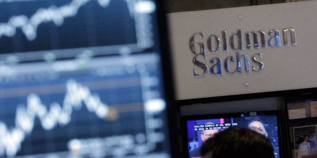 FILE - In this Oct. 16, 2014 file photo, a screen at a trading post on the floor of the New York Stock Exchange is juxtaposed with the Goldman Sachs booth. Goldman Sachs plans to start lending money directly to consumers and small businesses, according to an internal memo released to The Associated Press on Monday, June 15, 2015. It would be the first time in its history that the investment firm has done business with ordinary borrowers. (AP Photo/Richard Drew, File)