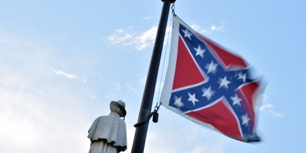 The Confederate flag is seen next to the monument of the victims of the Civil War in Columbia, South Carolina on June 20, 2015. The racially divisive Confederate battle flag flew at full-mast despite others flying at half-staff in South Carolina after the killing of nine black people in an historic African-American church in Charleston on June 17. Dylann Roof, the 21-year-old white male suspected of carrying out the Emanuel African Episcopal Methodist Church bloodbath, was one of many southern Americans who identified with the 13-star saltire in red, white and blue. AFP PHOTO/MLADEN ANTONOV (Photo credit should read MLADEN ANTONOV/AFP/Getty Images)