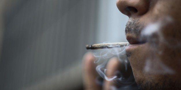 A man smokes a joint during a march calling for the legalization of marijuana at Paulista Avenue in Sao Paulo, Brazil, on May 23, 2015. Members of the Brazilian Association of Patients of Medical Cannabis and other people marched calling for the legalization of marijuana, either for its medical benefits or for recreational purposes. AFP PHOTO / MIGUEL SCHINCARIOL (Photo credit should read Miguel Schincariol/AFP/Getty Images)