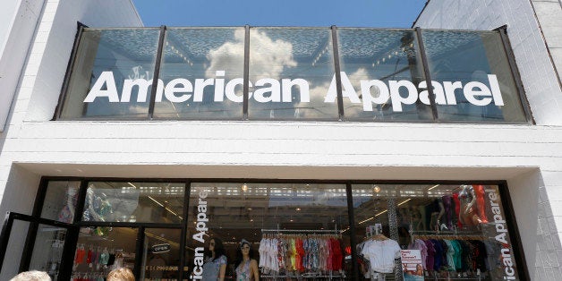 Passers-by walk down the street past the American Apparel store in the Shadyside neighborhood of Pittsburgh on Wednesday, Jul