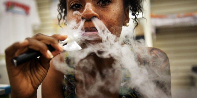 NEW YORK, NY - JUNE 10: Gabrielle Ortiz smokes an electronic cigarette at Vape New York, an electronic cigarette store on June 10, 2013 in New York City. Electronic cigarettes, or e-cigarettes, are battery powered devices that vaporizes a nicotine laced liquid solution into an aerosol mist which simulates the act of tobacco smoking. E-cigarettes are attracting major investors as their popularity increases and the market for traditional cigarettes continues to shrink. On Monday it was announced that Sean Parker will be investing $75 million in a leading maker of electronic cigarettes. (Photo by Spencer Platt/Getty Images)