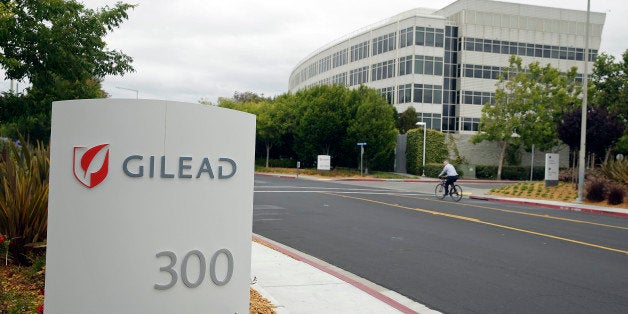 In this photo taken Thursday, July 9, 2015, a man cycles near the headquarters of Gilead Sciences in Foster City, Calif. (AP Photo/Eric Risberg)