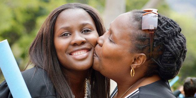 Proud mother kissing her daughter at her daughters graduation ceremony. Cape Town, South Africa.