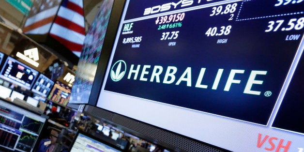 FILE - In this Feb. 28, 2013, file photo, a pair of specialists confer at the post that handles Herbalife on the floor of the New York Stock Exchange. A judge dismissed a lawsuit Tuesday, March 17, 2015, by Herbalife shareholders who claimed that the business structure and marketing practices of the weight loss and nutritional supplements company violated the law and that they lost money in what amounts to a pyramid scheme. (AP Photo/Richard Drew, File)