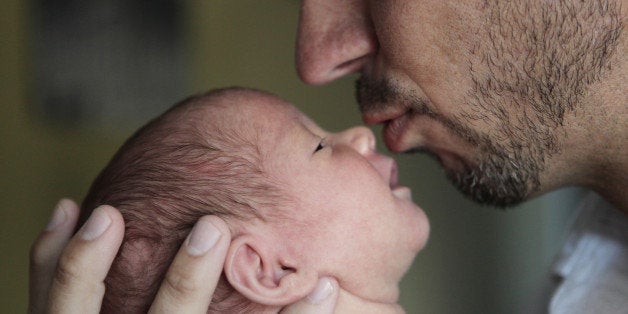 Father kissing his newborn