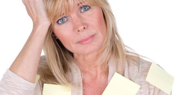 mature woman with post it reminders all over her body as forgetfulness concept