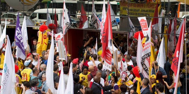 Demonstrators protest for better wages and working conditions for McDonald's employees, in Sao Paulo, Brazil, Tuesday, Aug. 18, 2015. The protest gathered McDonald's workers, union representatives from 20 countries, and members of the Restaurant Workers Union. (AP Photo/Andre Penner)