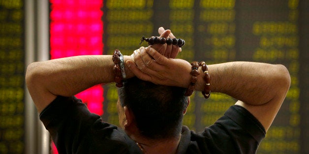 A Chinese investor monitors stock prices at a brokerage house in Beijing, Monday, Aug. 24, 2015. Stocks tumbled across Asia on Monday as investors shaken by the sell-off last week on Wall Street unloaded shares in practically every sector. (AP Photo/Mark Schiefelbein)